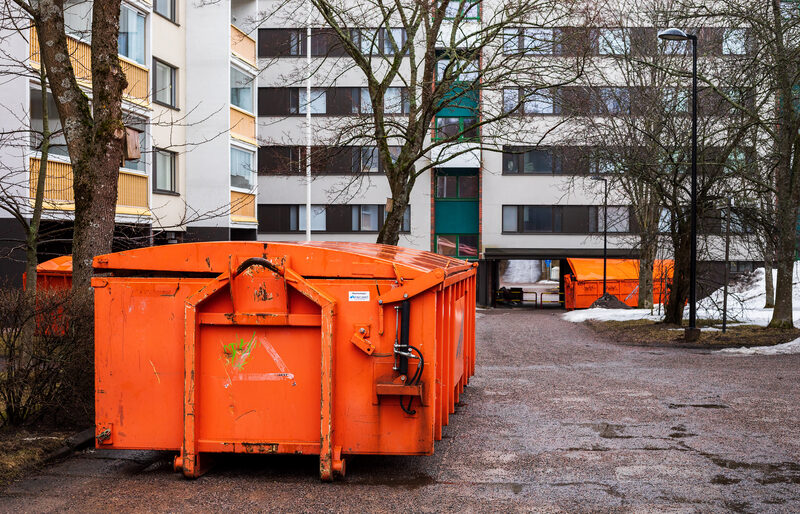 Large orange 7 cubic metre maxi skip bins stationed at an apartment block