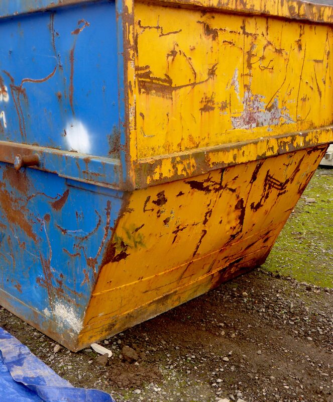 Close view of a weathered blue and yellow 4.5 cubic metre small skip bin