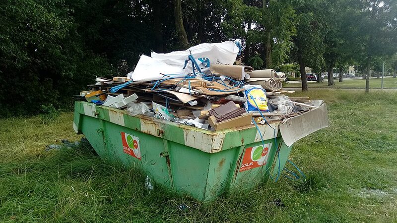 Green 4.5 cubic metre skip bin overloaded with household rubbish and cardboard